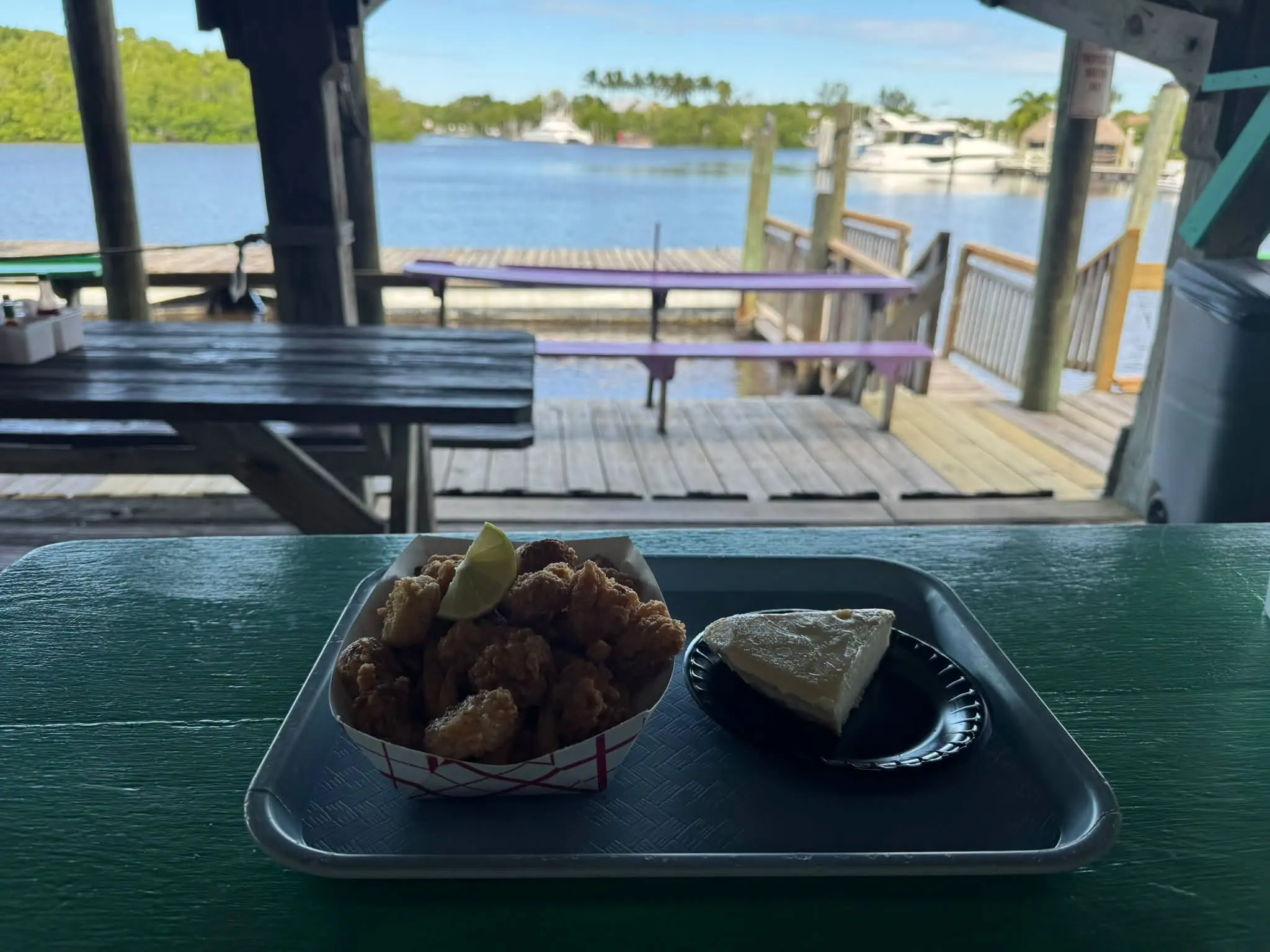 A tray of fried seafood and key lime pie on a dockside table overlooking the Barron River